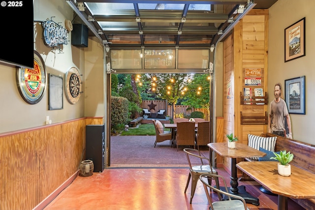 18287 SW Florendo Ln, Beaverton, OR 97007 - dining area with wood walls, concrete flooring, and a wainscoted wall