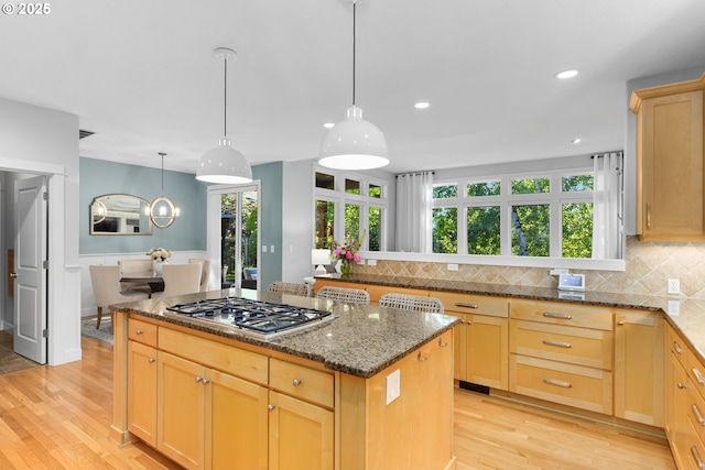 18287 SW Florendo Ln, Beaverton, OR 97007 - kitchen with stainless steel gas stovetop, a kitchen island, light wood finished floors, decorative backsplash, and recessed lighting