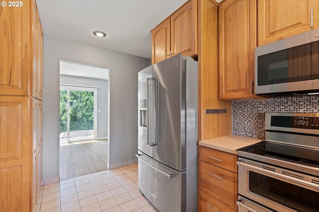 721 NW 76th St, Vancouver, WA 98665 - kitchen with appliances with stainless steel finishes, backsplash, light tile patterned flooring, light countertops, and baseboards