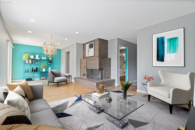 721 NW 76th St, Vancouver, WA 98665 - living room with recessed lighting, wood finished floors, a chandelier, a brick fireplace, and a textured ceiling