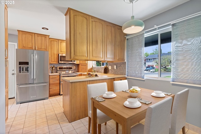 721 NW 76th St, Vancouver, WA 98665 - kitchen with stainless steel appliances, backsplash, a peninsula, light tile patterned flooring, and light countertops