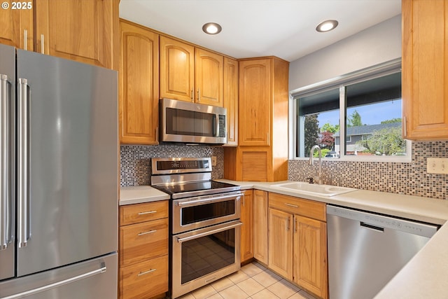 721 NW 76th St, Vancouver, WA 98665 - kitchen with stainless steel appliances, a sink, light countertops, light tile patterned floors, and recessed lighting
