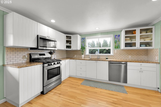 35478 Brabham Rd, Pleasant Hill, OR 97455 - kitchen with appliances with stainless steel finishes, a sink, glass insert cabinets, light stone countertops, and white cabinetry