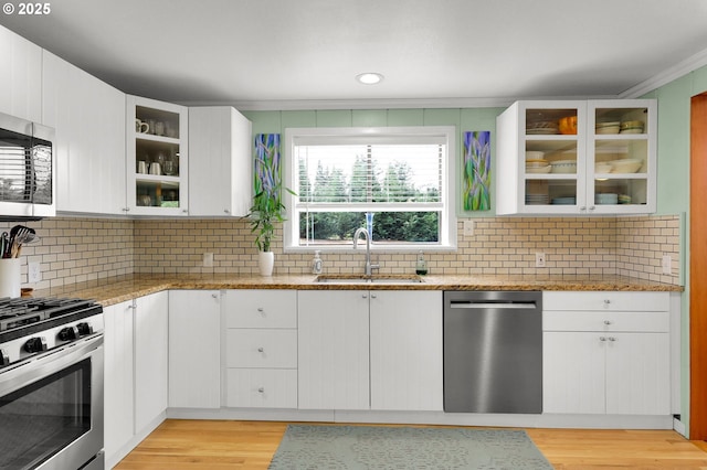 35478 Brabham Rd, Pleasant Hill, OR 97455 - kitchen featuring stainless steel appliances, a sink, light wood-style floors, white cabinetry, and ornamental molding