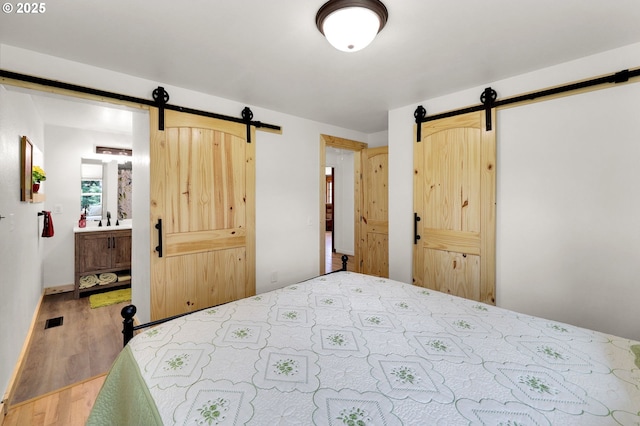 35478 Brabham Rd, Pleasant Hill, OR 97455 - bedroom with a barn door, wood finished floors, and a sink