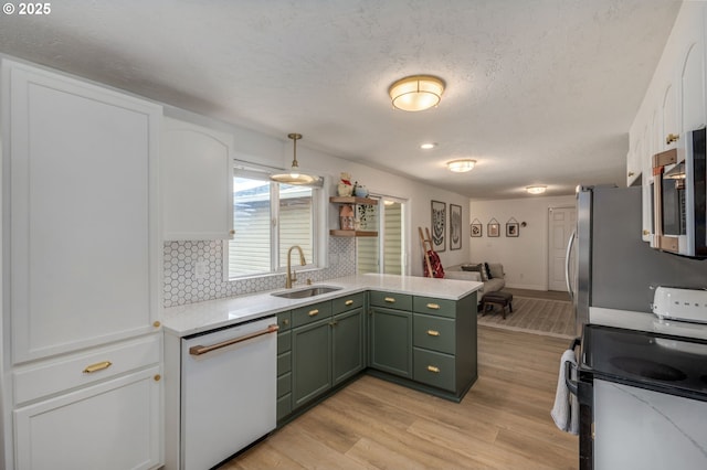 1001 S Grant St, Canby, OR 97013 - kitchen with green cabinetry, dishwasher, electric stove, stainless steel microwave, and a peninsula