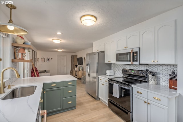 1001 S Grant St, Canby, OR 97013 - kitchen featuring white microwave, black range with electric cooktop, light wood-style floors, white cabinets, and decorative backsplash