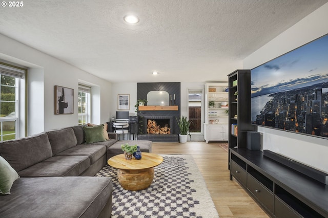 1001 S Grant St, Canby, OR 97013 - living room featuring a textured ceiling, light wood-type flooring, a large fireplace, and recessed lighting