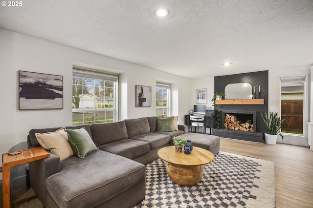 1001 S Grant St, Canby, OR 97013 - living room featuring a brick fireplace, wood finished floors, a textured ceiling, and recessed lighting