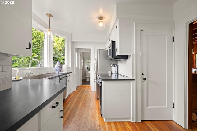 1667 Lake Front Rd, Lake Oswego, OR 97034 - kitchen featuring dark countertops, stainless steel appliances, white cabinets, and tasteful backsplash