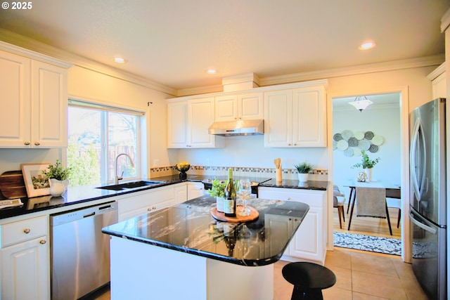 kitchen featuring under cabinet range hood, appliances with stainless steel finishes, white cabinets, and a sink