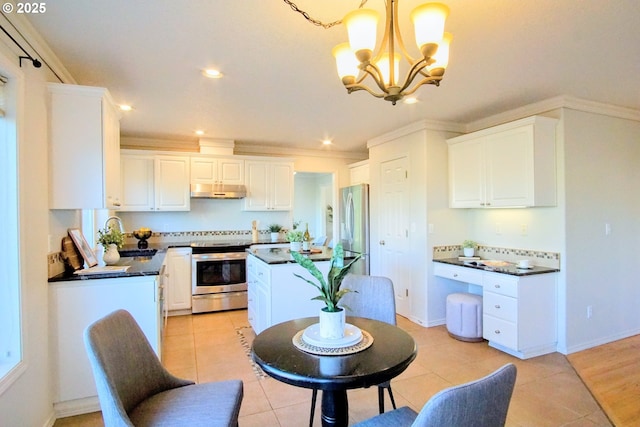 kitchen featuring stainless steel appliances, dark countertops, a sink, and white cabinets