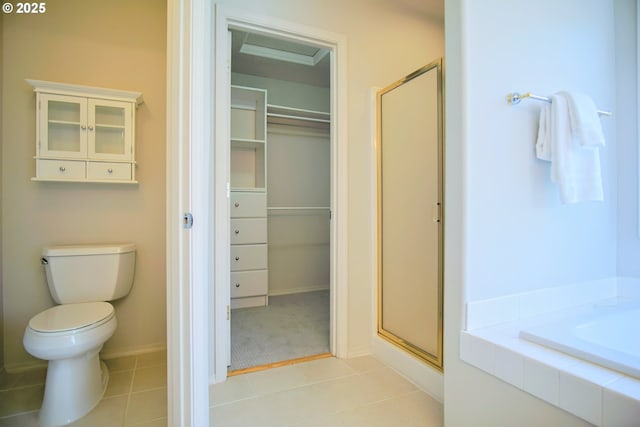 full bath with a walk in closet, a garden tub, toilet, a stall shower, and tile patterned flooring