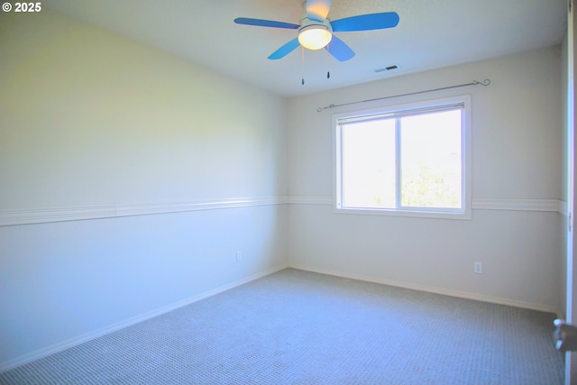 spare room with carpet, visible vents, ceiling fan, and baseboards