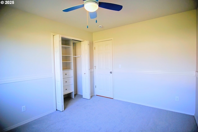 unfurnished bedroom with a closet, a ceiling fan, and light colored carpet