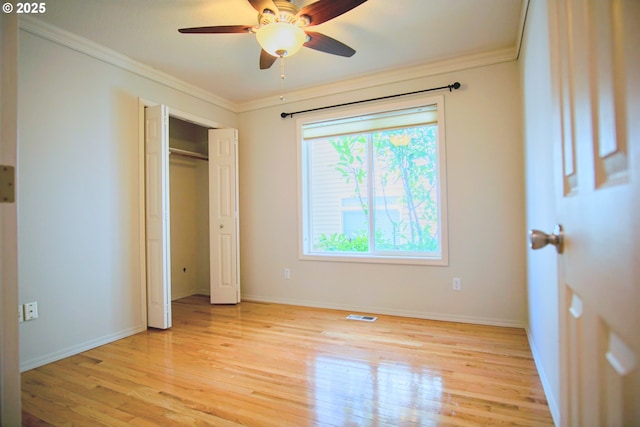 unfurnished bedroom with baseboards, light wood-style flooring, visible vents, and crown molding