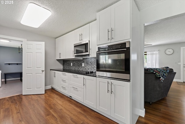 1050 D St, Baker City, OR 97814 - kitchen featuring stainless steel appliances, a textured ceiling, tasteful backsplash, dark wood-style floors, and dark countertops
