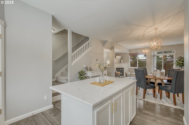 kitchen with pendant lighting, hardwood / wood-style floors, a center island, and white cabinets