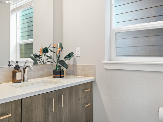 bathroom with backsplash, vanity, and a wealth of natural light