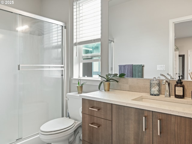 bathroom featuring walk in shower, vanity, and toilet