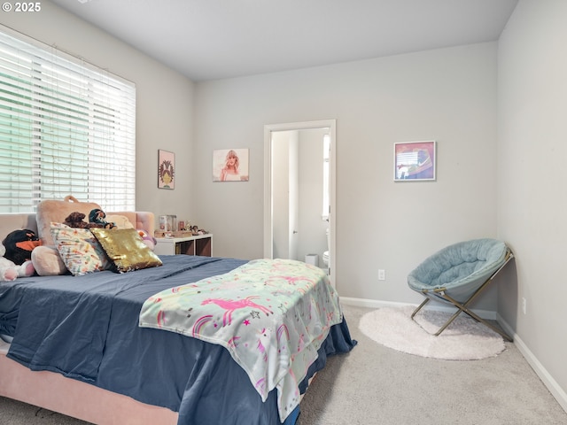 bedroom featuring ensuite bathroom and carpet flooring