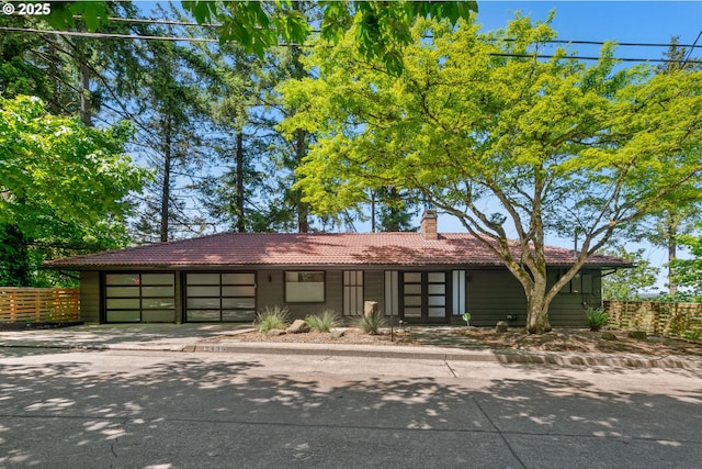 2435 Skyline Blvd, Eugene, OR 97403 - view of front of property with a tile roof, a garage, driveway, fence, and a chimney
