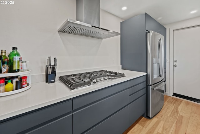 2435 Skyline Blvd, Eugene, OR 97403 - kitchen featuring wall chimney exhaust hood, stainless steel appliances, light wood-style flooring, gray cabinets, and light countertops