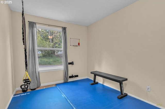 exercise room featuring carpet floors and baseboards