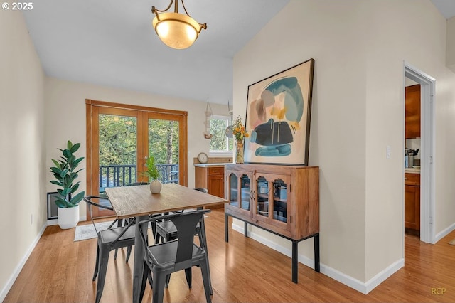 dining space with light wood-type flooring and baseboards