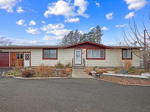 ranch-style house with aphalt driveway and an attached garage