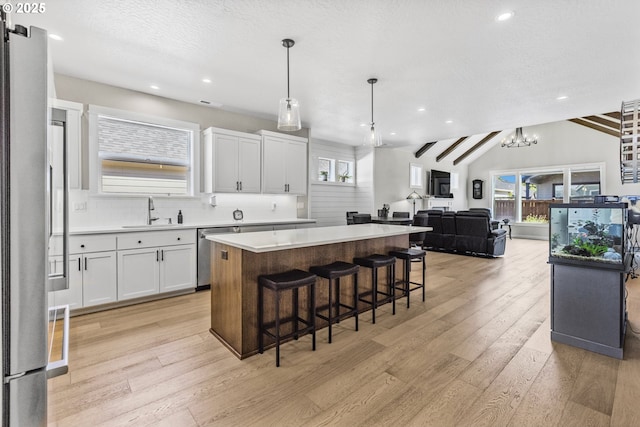 32750 Macy St, Eugene, OR 97408 - kitchen featuring stainless steel appliances, a kitchen island, light wood-style flooring, white cabinets, and light countertops