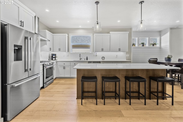 32750 Macy St, Eugene, OR 97408 - kitchen featuring high end appliances, a center island, light wood-style floors, tasteful backsplash, and light countertops