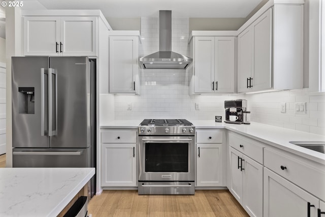 32750 Macy St, Eugene, OR 97408 - kitchen featuring stainless steel appliances, wall chimney exhaust hood, light wood-type flooring, and tasteful backsplash