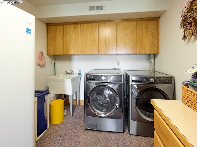 clothes washing area featuring a sink, cabinet space, visible vents, carpet, and washer and dryer