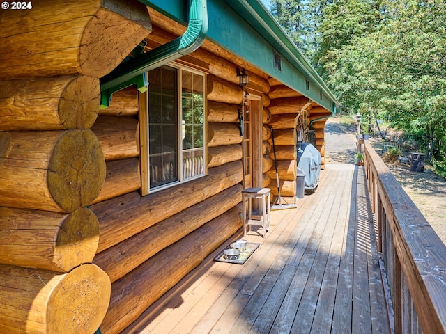 exterior space with a deck and log siding