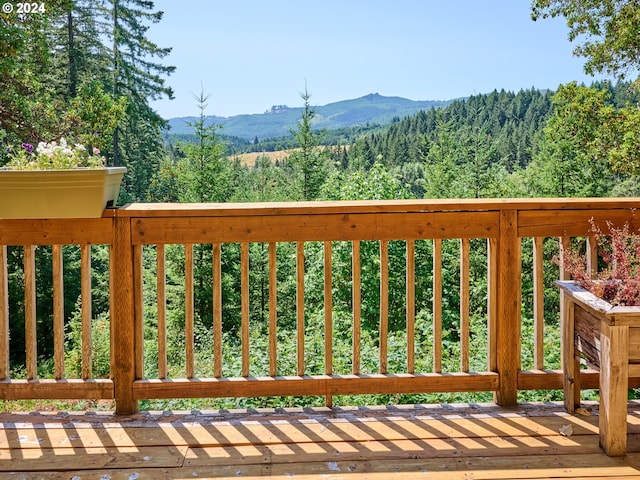 wooden deck with a mountain view and a view of trees
