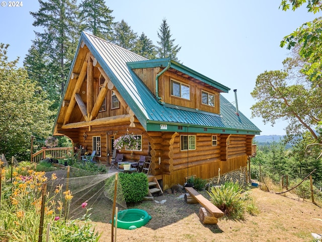 rear view of property with metal roof and log siding