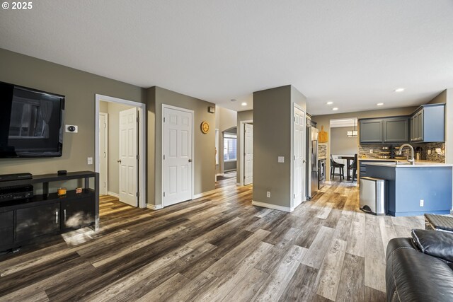 22647 SW Saunders Dr, Sherwood, OR 97140 - kitchen with baseboards, wood finished floors, a sink, light countertops, and tasteful backsplash