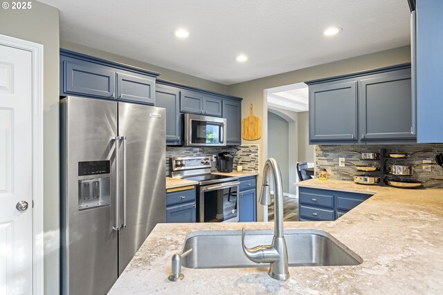 22647 SW Saunders Dr, Sherwood, OR 97140 - kitchen featuring stainless steel appliances, a sink, light wood-style floors, recessed lighting, and backsplash