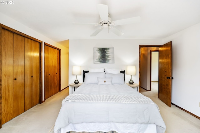 bedroom with multiple closets, ceiling fan, and light colored carpet