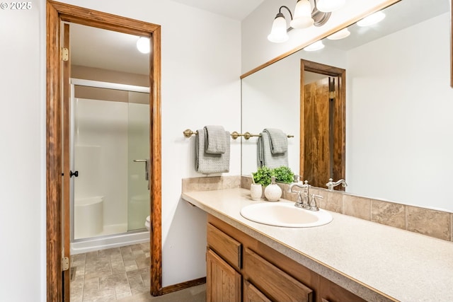 bathroom with vanity, baseboards, and a stall shower