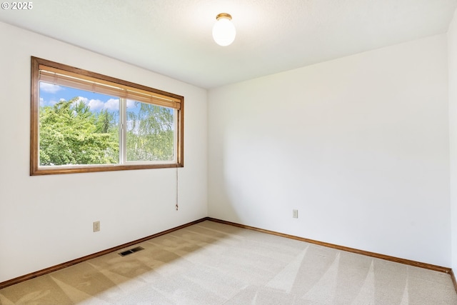 unfurnished room with visible vents, baseboards, and light carpet