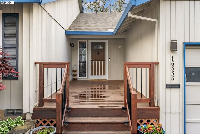 property entrance featuring a deck and a shingled roof