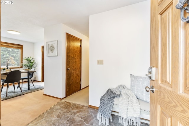 foyer featuring carpet floors and baseboards