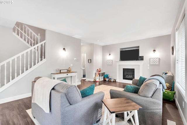 living room featuring a wealth of natural light and dark wood-type flooring