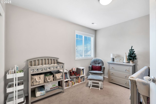 bedroom featuring light colored carpet and a nursery area