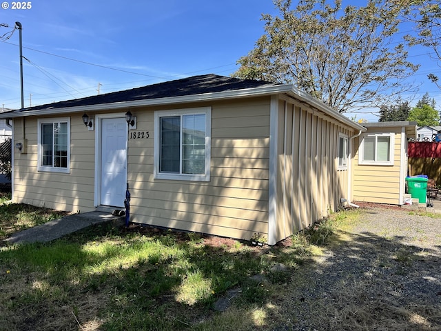 rear view of property with board and batten siding and fence