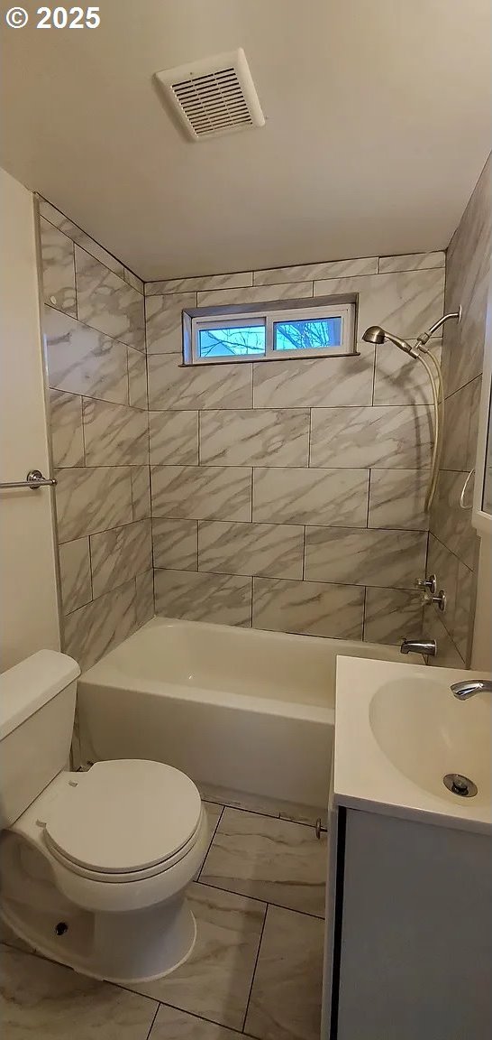 full bath featuring toilet, shower / washtub combination, vanity, and marble look tiles