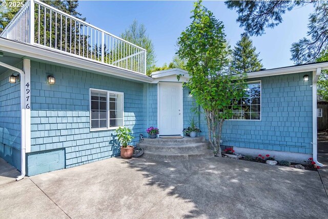 4976 NE K Ave, Neotsu, OR 97364 - view of exterior entry with roof with shingles and a patio