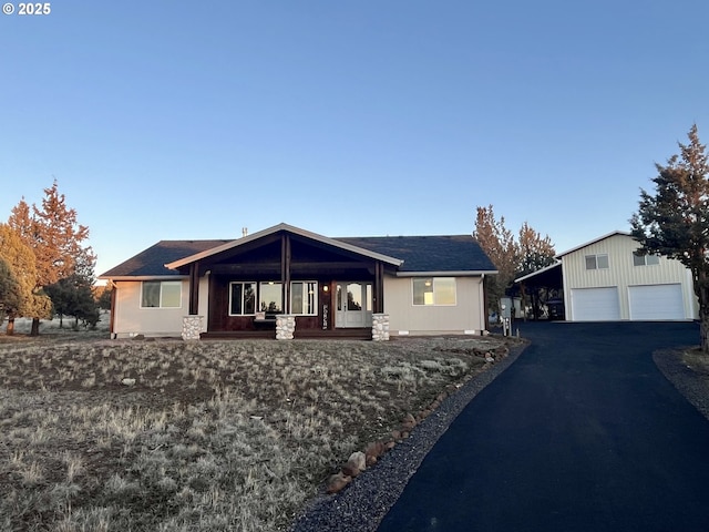 single story home featuring a carport and an outbuilding